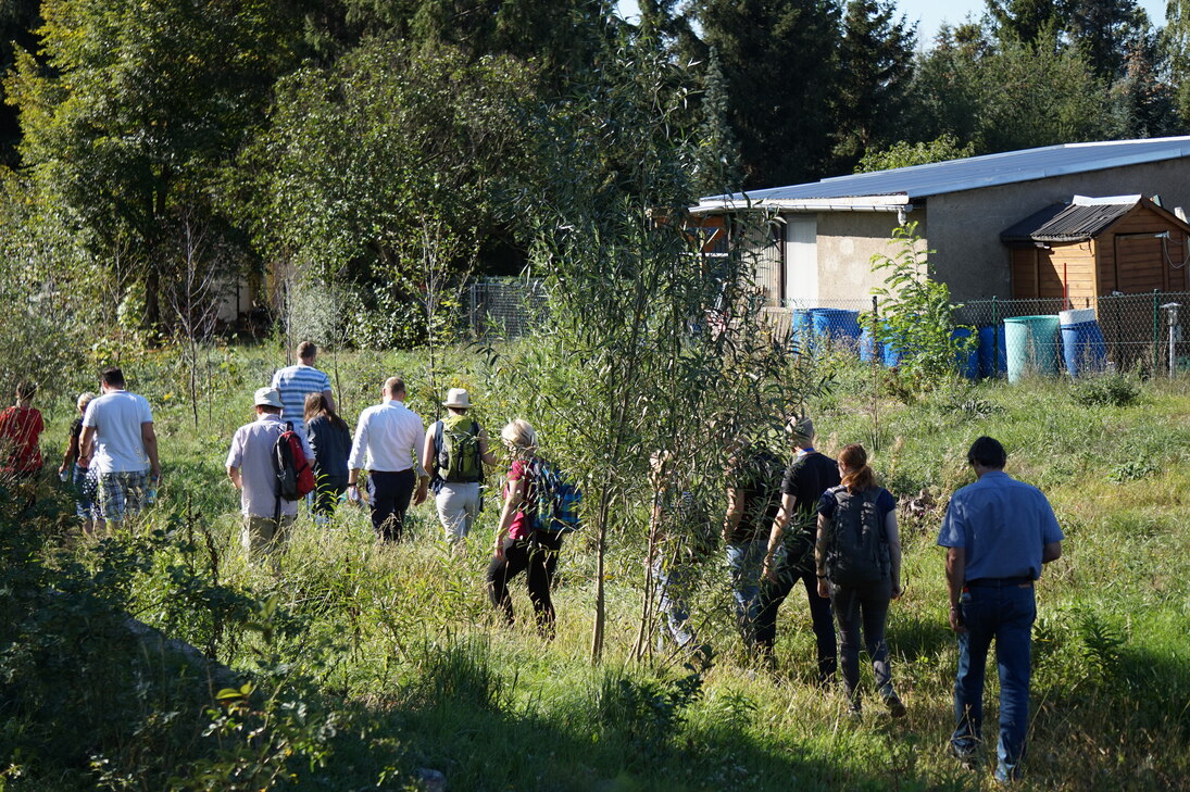 Účastníci exkurze procházejí kolem koryta potoka Lockwitzbach a seznamují se s provedenými opatřeními bioinženýringu. 